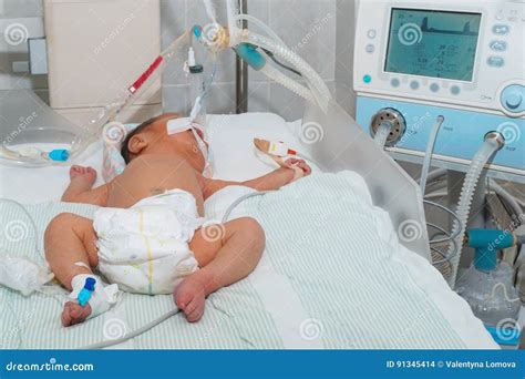 Imagen de una incubadora con un neonato conectado a soporte respiratorio