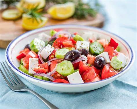 Foto de una ensalada griega tradicional con queso feta en dados, tomates, pepino, cebolla y aceitunas