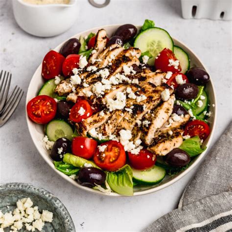 Ensalada griega con pollo marinado y aderezo cremoso en un bol grande