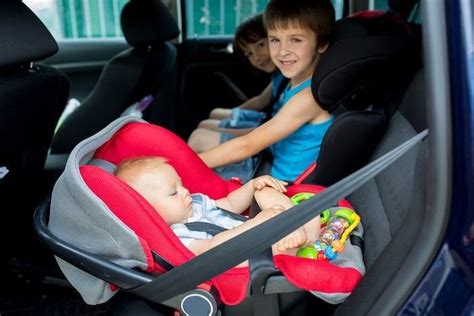 Foto de bebé dormido cómodamente en su silla de coche con almohada cervical