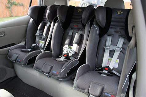 Foto de tres sillas de coche estrechas instaladas en el asiento trasero de un coche