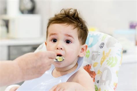 Bebé de un año comiendo alimentos sólidos y amamantando
