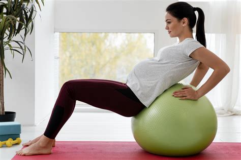 Mujer embarazada realizando ejercicios de preparación al parto con un fisioterapeuta