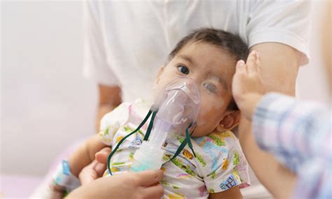 Bebé con dificultad respiratoria siendo examinado por un pediatra