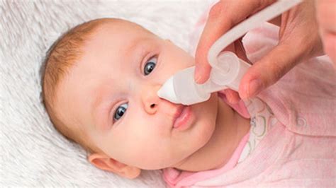 Madre realizando un lavado nasal a un recién nacido