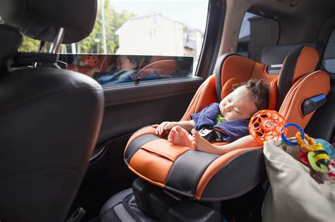 Foto temática: padre o madre instalando una silla de coche para bebé en un automóvil