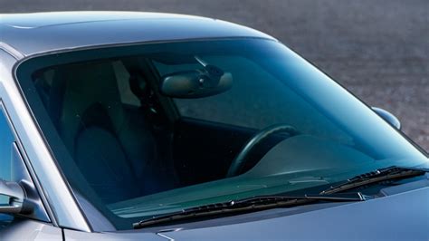 Ilustración de un coche con varias pegatinas en el parabrisas y la carrocería.