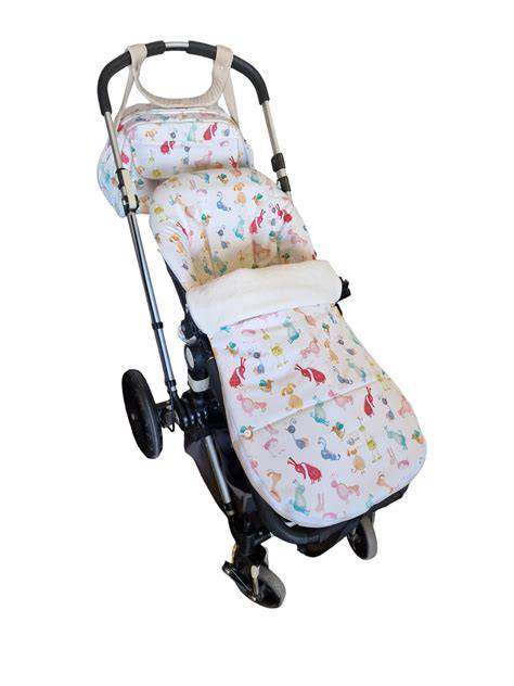 Esquema ilustrativo de un bebé protegido en una silla de paseo con saco térmico adaptado.