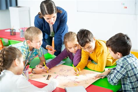 Profesores interactuando con niños en un aula de inglés