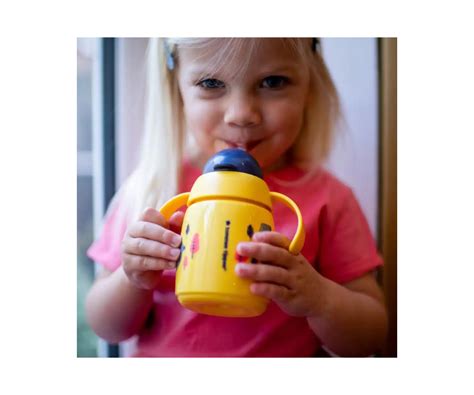 Foto de bebé intentando beber de una taza de entrenamiento