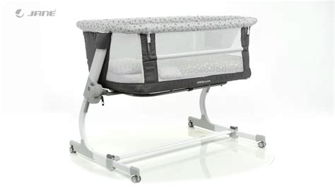 Cuna colecho Jané Babyside con un lateral bajado junto a una cama de matrimonio