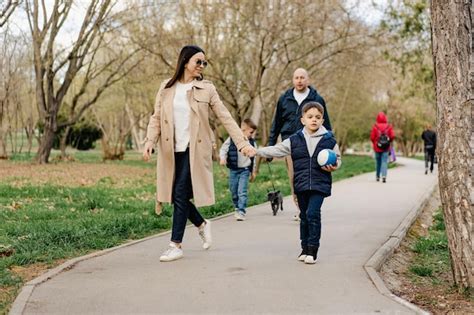 Foto de familia feliz paseando con silla de paseo por el paseo marítimo de Benidorm