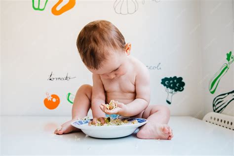 bebé comiendo solo con las manos, explorando alimentos