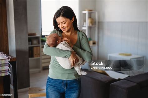 Foto de una madre abrazando a su bebé mientras le da el biberón, con un gesto de ternura y amor.