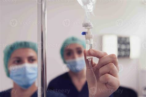 Equipo de enfermeras pediátricas realizando un procedimiento intravenoso en un neonato en UCI.