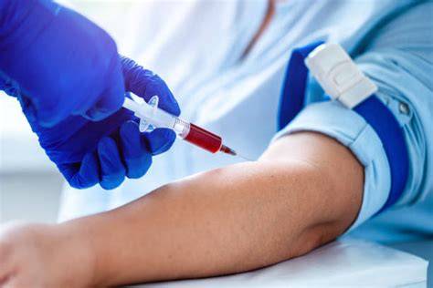 Foto de una enfermera realizando una extracción de sangre del brazo de una mujer embarazada