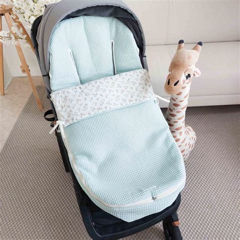 Esquema de un saco para silla de paseo con sus componentes principales (capucha, relleno, cubierta, cremalleras)