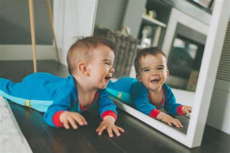 Bebé sonriendo a su reflejo en un espejo de actividades