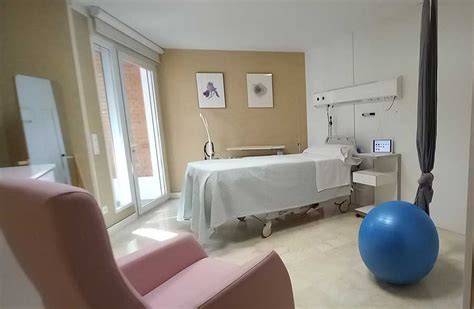 Foto de una sala de parto moderna con recursos como pelotas de pilates y sillas de parto