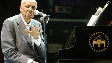 Fotografía en blanco y negro de Bebo Valdés tocando el piano con elegancia.