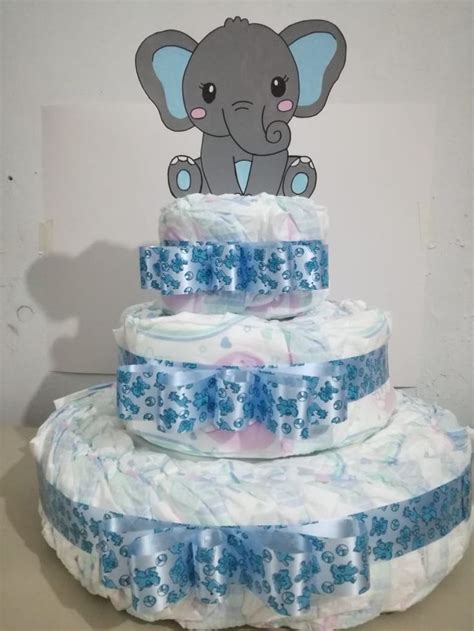 Pastel de pañales decorado con elementos de bebé y cintas