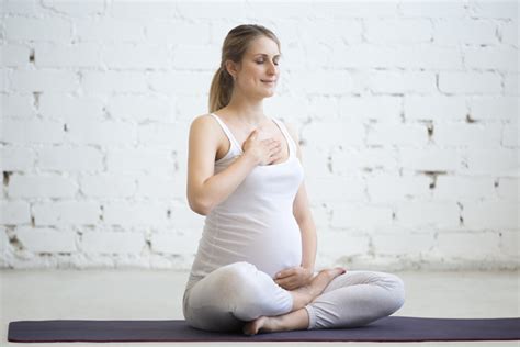 Mujer embarazada practicando ejercicios de respiración y relajación.