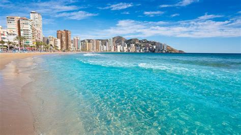 Playa de Levante en Benidorm con arena dorada y aguas cristalinas.