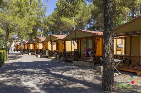 Familia disfrutando en un bungalow de camping con zona ajardinada.