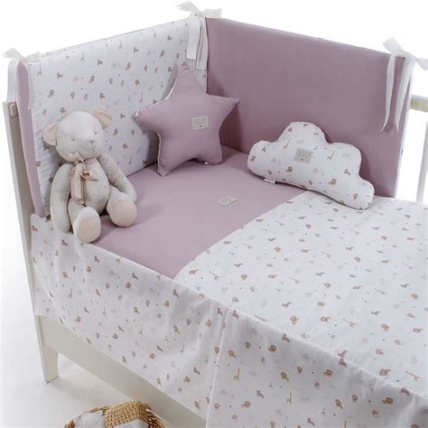 Cuna de bebé vestida con colcha y protector acolchado