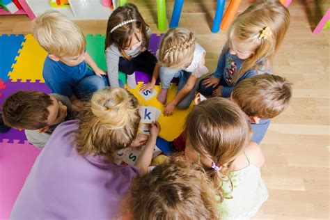 Foto de una escuela infantil con niños jugando supervisados por educadores
