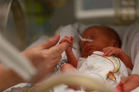 Foto: Familia participando en el cuidado de su bebé prematuro en una unidad de neonatos