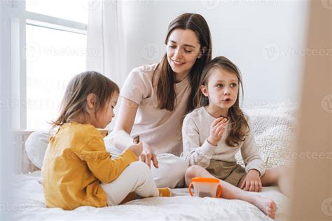 Foto de una familia (madre e hijos) sentada, mirándose y abrazándose con expresión de apoyo mutuo en un momento de reflexión