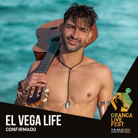 Foto de El Vega Life actuando en un concierto al aire libre, descalzo y con su guitarra
