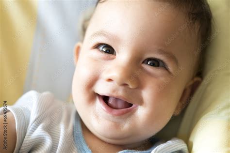 Foto de un bebé sonriendo en un cambiador con una funda suave y limpia
