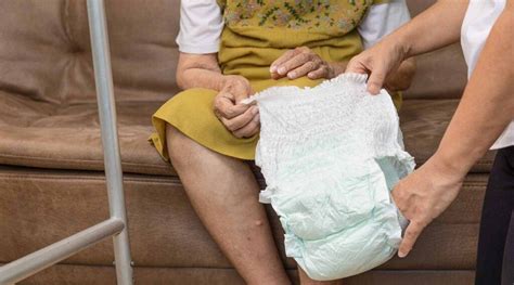 Persona mayor sentada cómodamente, con productos para el cambio de pañal organizados