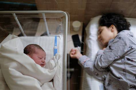 Personal de enfermería atendiendo a un bebé en una cuna