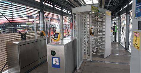 Foto de los torniquetes de piso a techo en una estación de TransMilenio