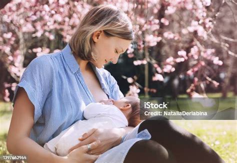 Foto de una madre amamantando a su bebé usando un cojín de lactancia para un soporte ergonómico