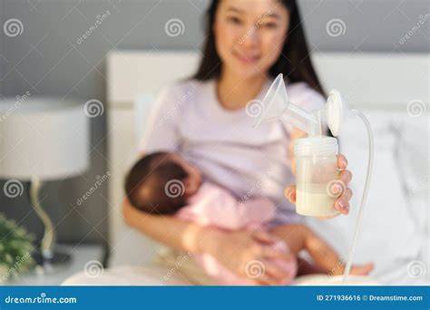 Madre extrayéndose leche mientras el bebé duerme