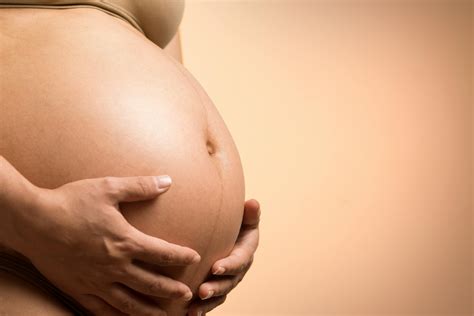 Foto de una mujer embarazada tocándose la barriga