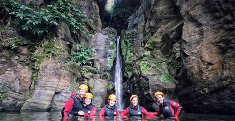 Grupo de personas practicando barranquismo en la cascada Salto do Cabrito con equipo de seguridad