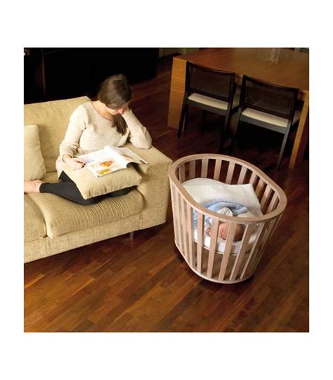 Minicuna de madera con barrotes y textiles suaves