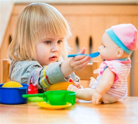 Foto de un niño o niña alimentando a una muñeca con el biberón mágico de Antonio Juan.