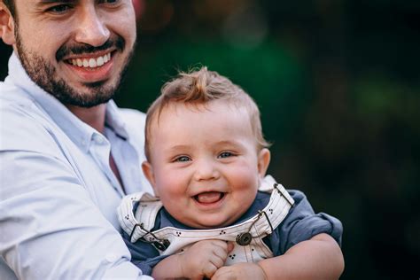 Foto de padre porteando a su bebé sonriente, mostrando conexión y seguridad