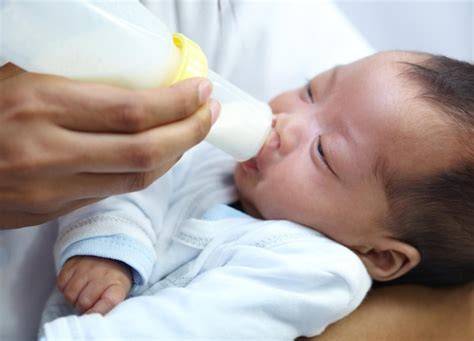 Bebé alimentándose con biberón y tetina