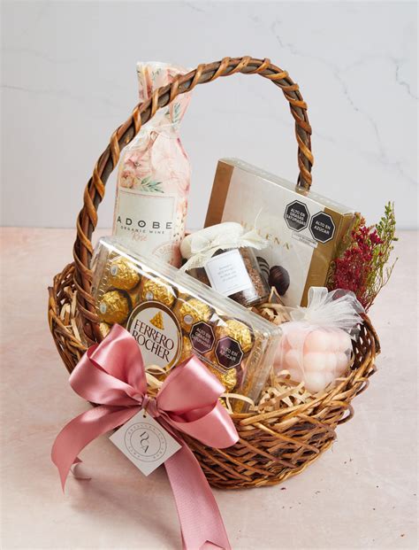 Foto de una canasta de regalo para una nueva mamá llena de artículos de cuidado personal y snacks