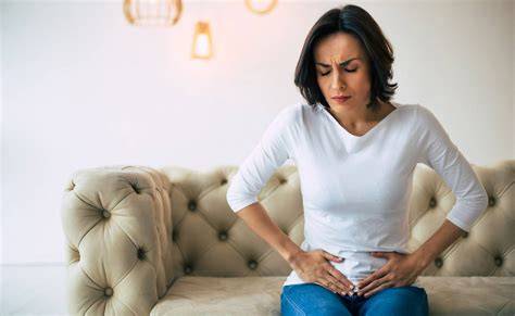 Mujer señalando dolor pélvico o médico realizando ecografía pélvica