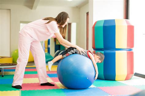 Niño realizando ejercicios en una pelota de fisioterapia pediátrica