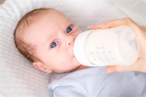 Bebé siendo alimentado con biberón con leche en polvo
