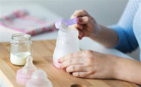 Padre o madre preparando biberón para salir de casa